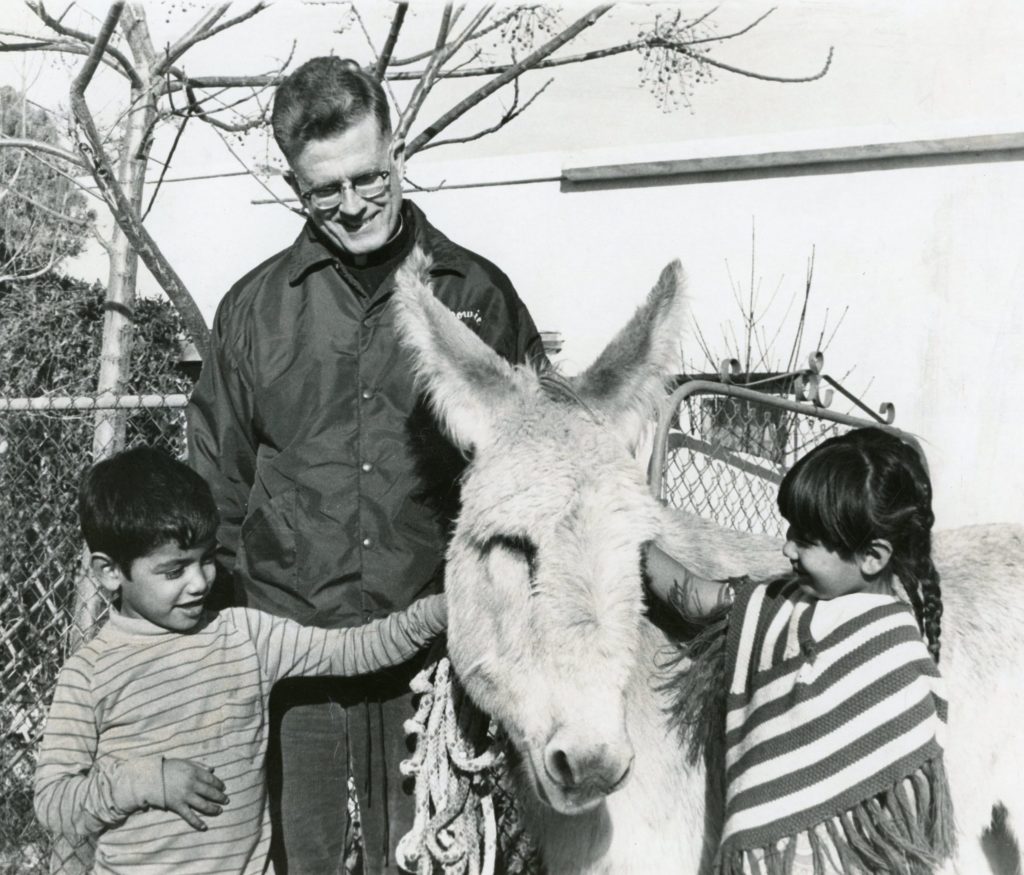Fr. Thomas with two children and a donkey.