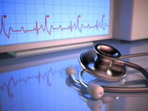 Stethoscope in front of the heartbeat monitor.