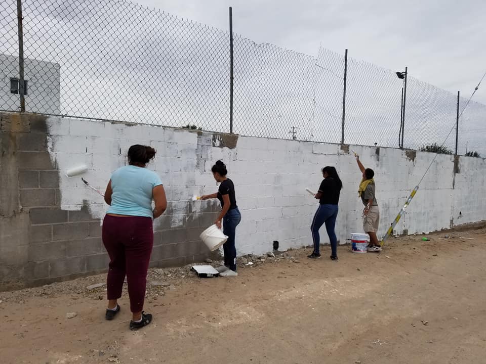 youth painting cinder block walls