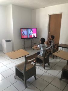 two boys watching class on TV
