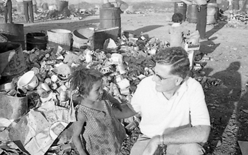 Father Thomas with child at the garbage dump