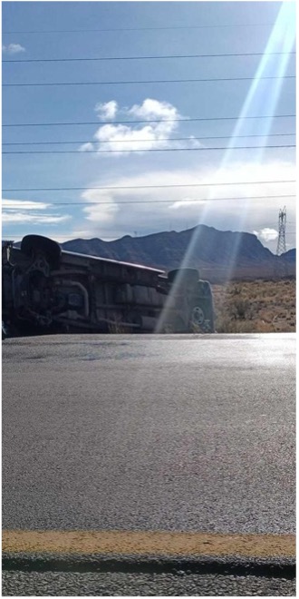 van flipped on its side by the highway