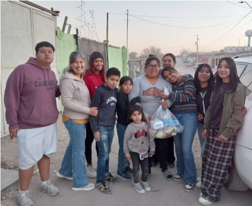 youth bringing groceries to a single mom and her children in a poor area