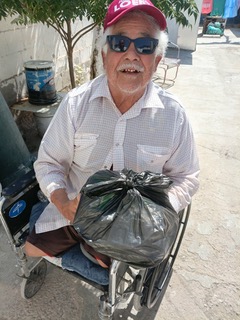 Man with amputated legs receiving groceries.